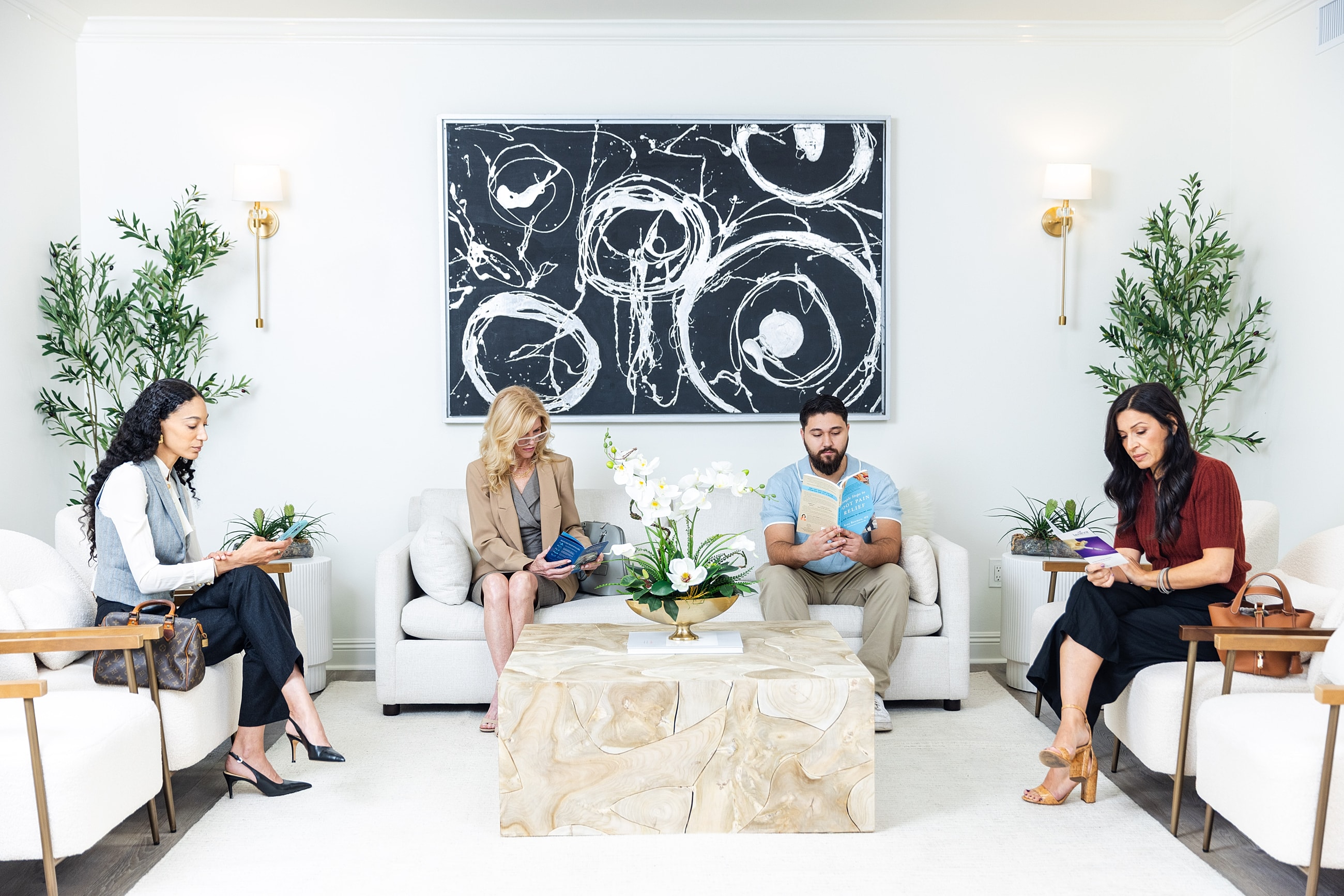 People reading and waiting in modern waiting room.