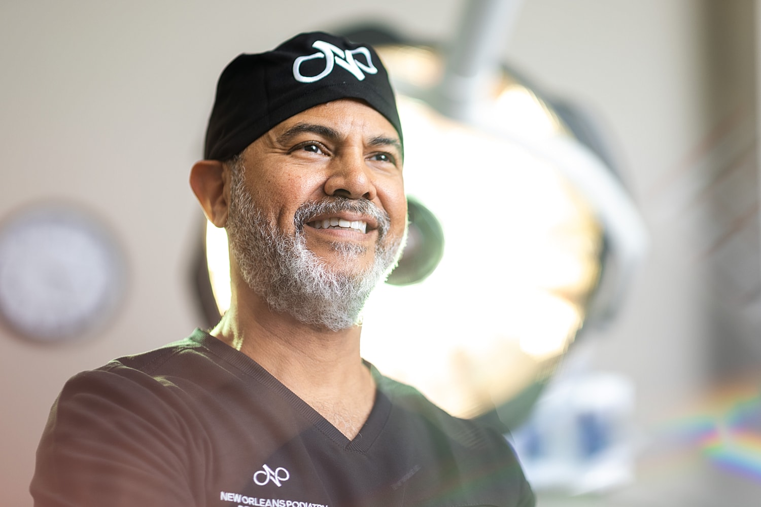 Smiling healthcare professional in surgical attire.