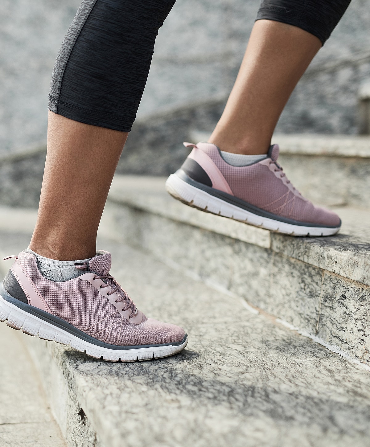 Man in black suit seated on white stool.