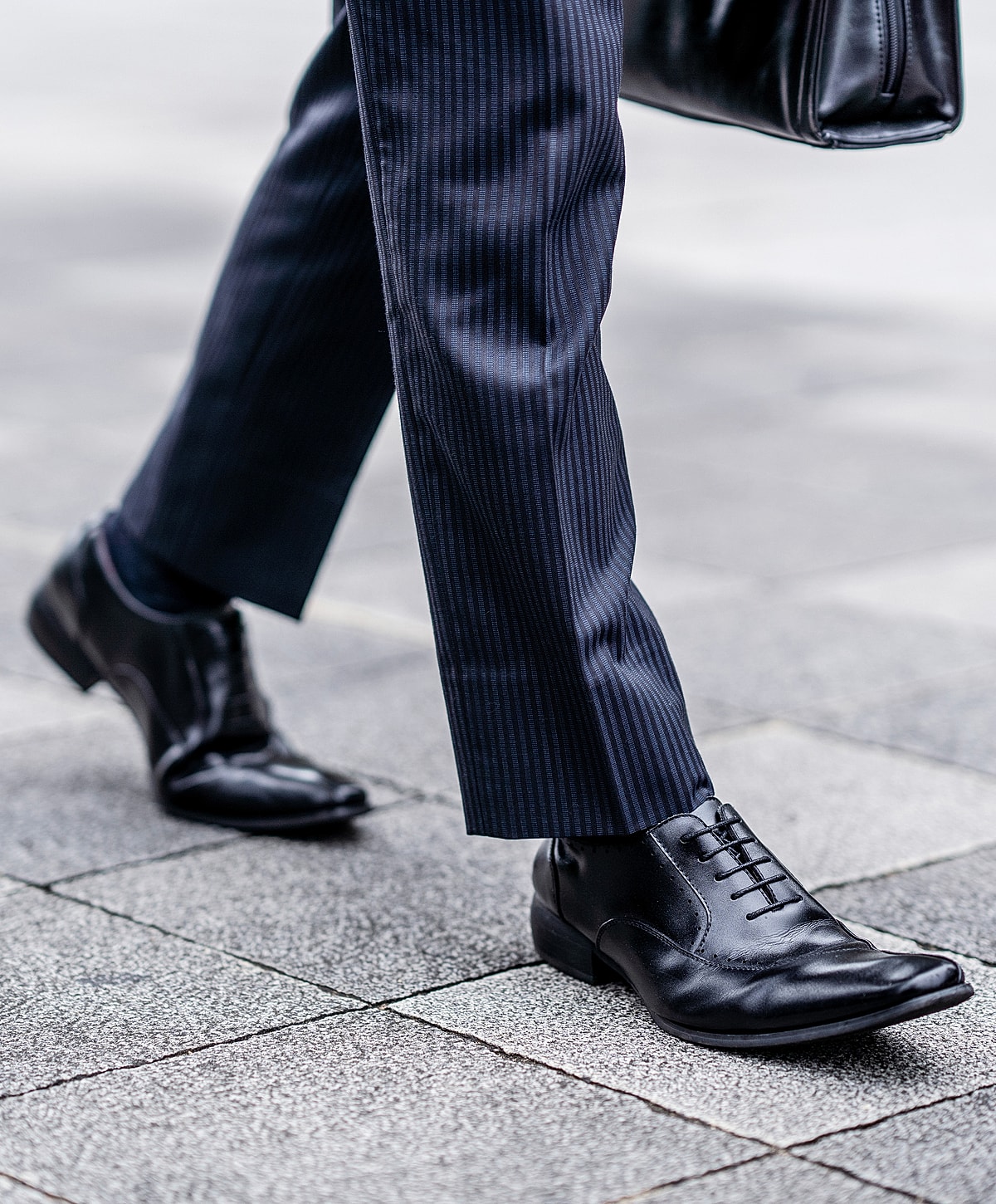 Business attire shoes on a city sidewalk.