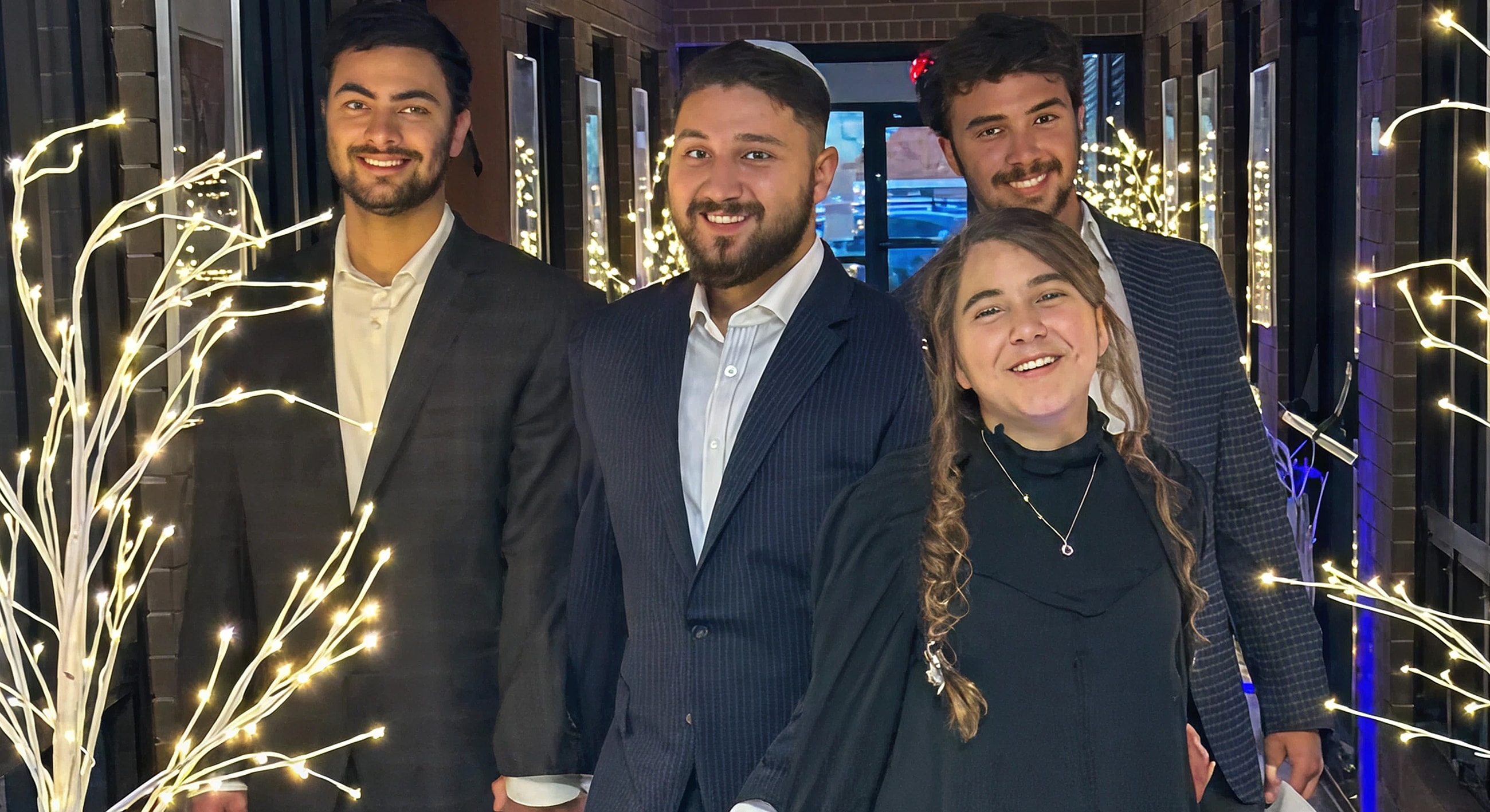 Group of smiling friends in a decorated hallway.