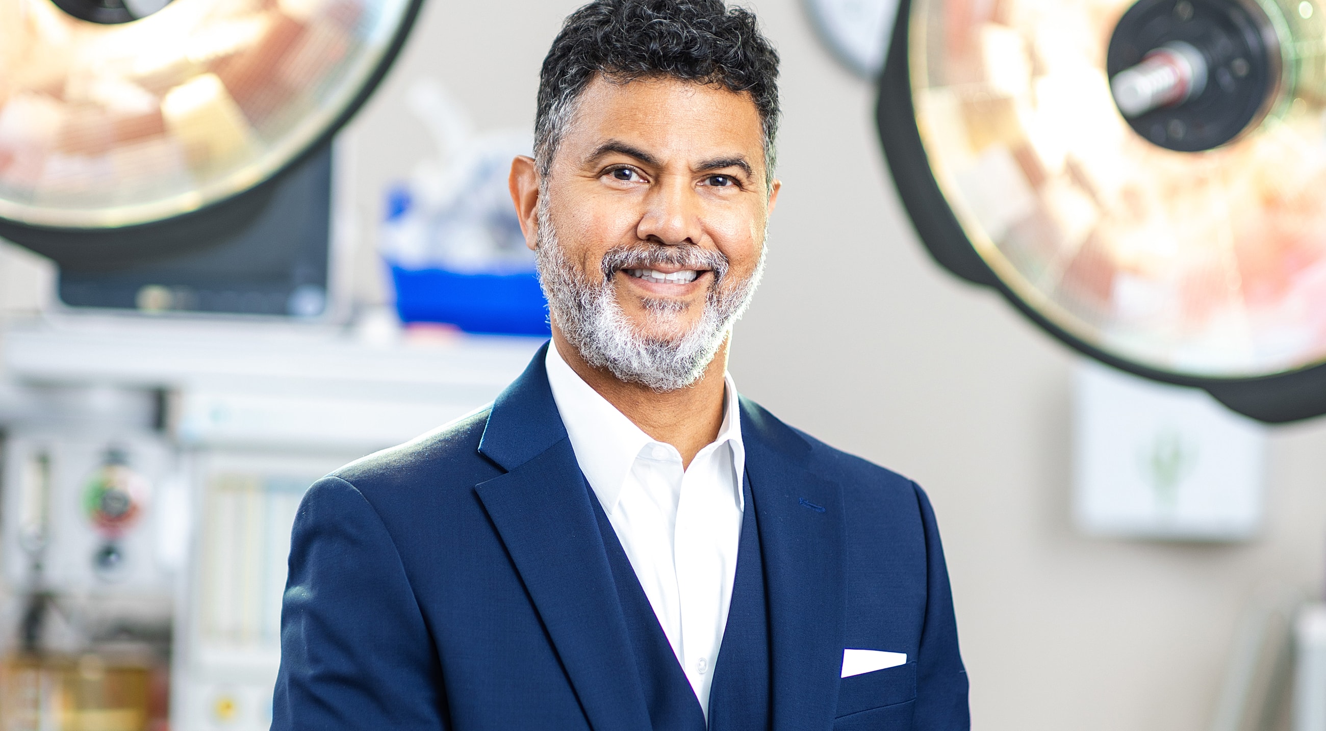 Smiling man in a professional setting with equipment.