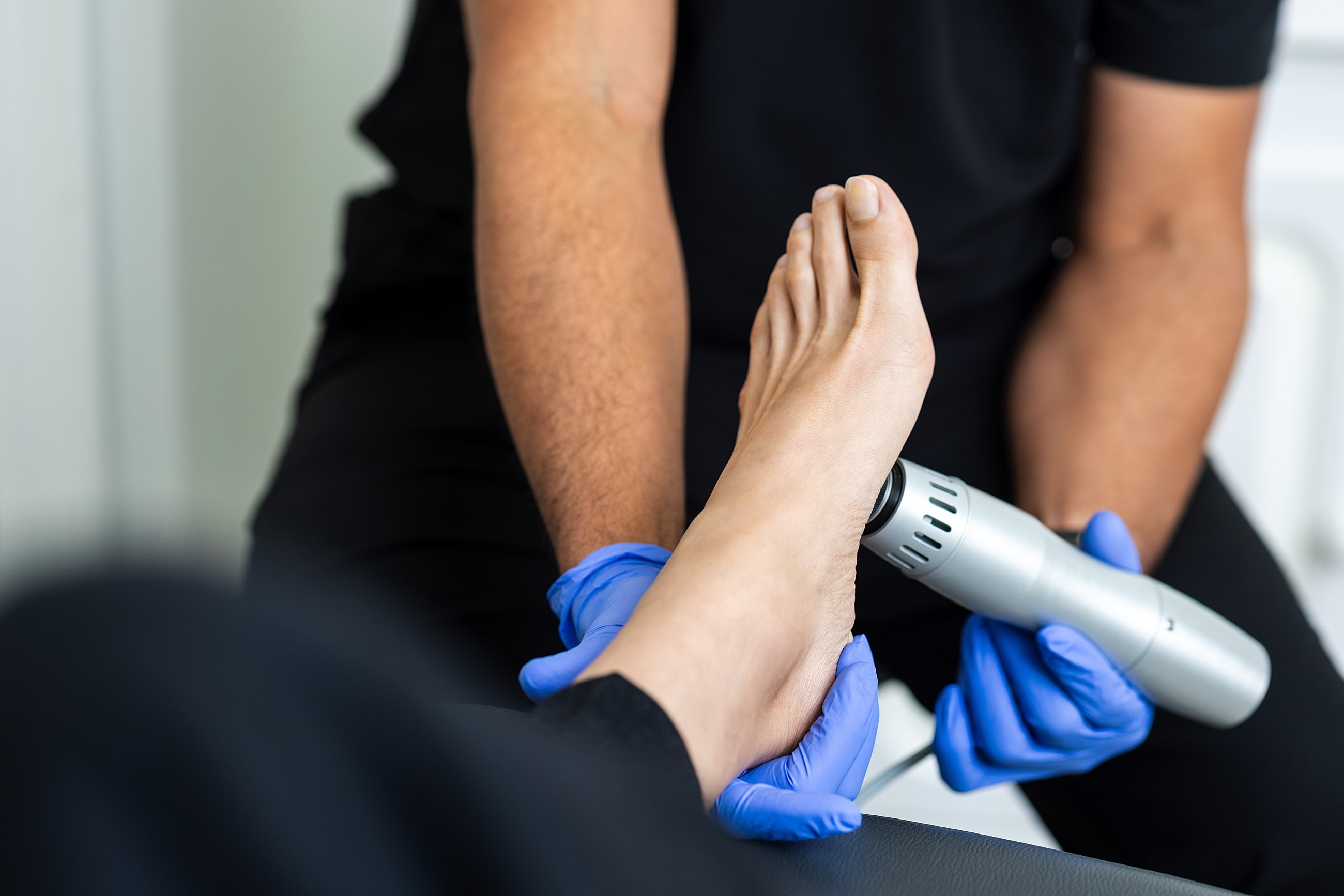 Woman relaxing, removing high heels, massaging foot.