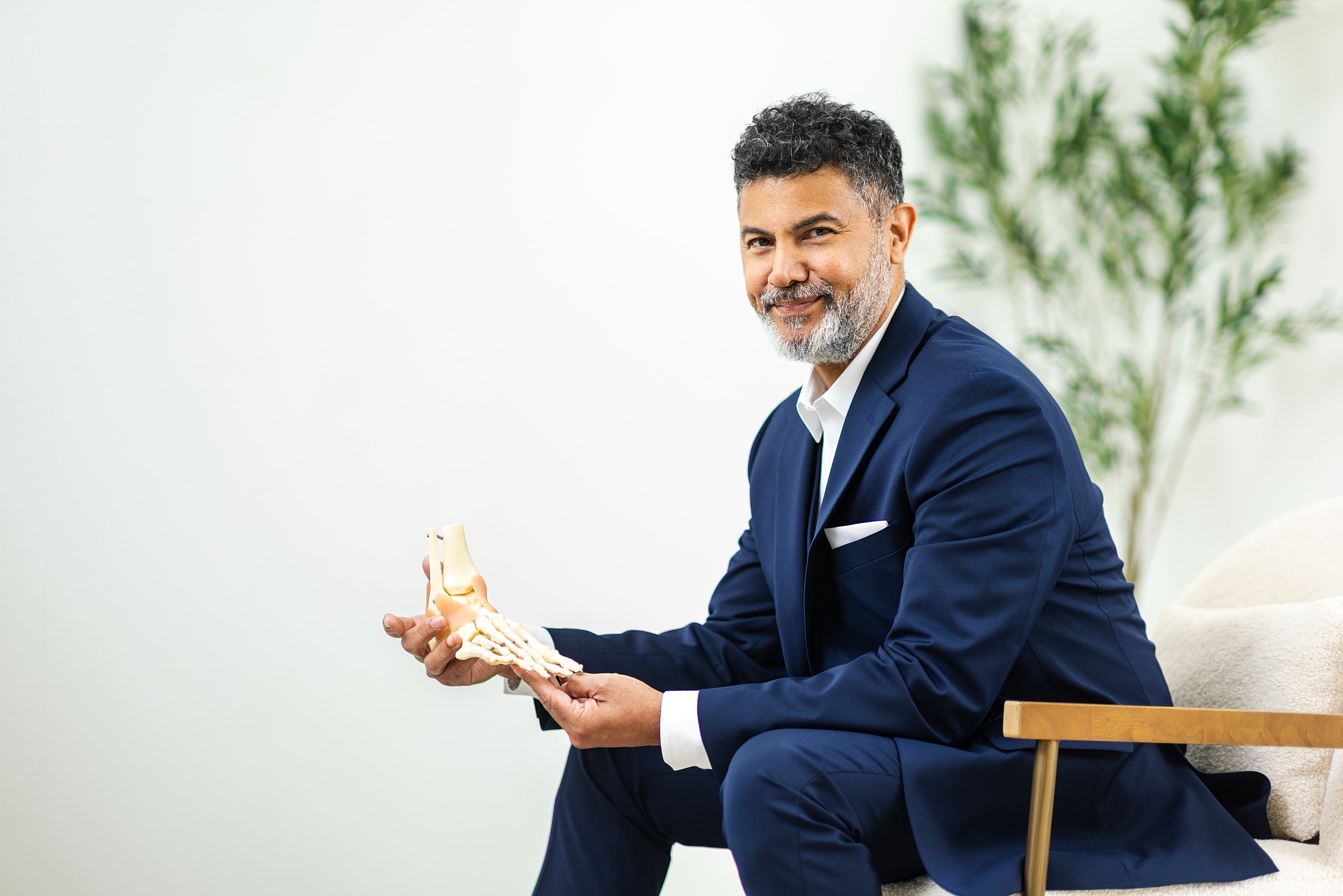 Woman adjusting black high-heeled shoes outdoors.