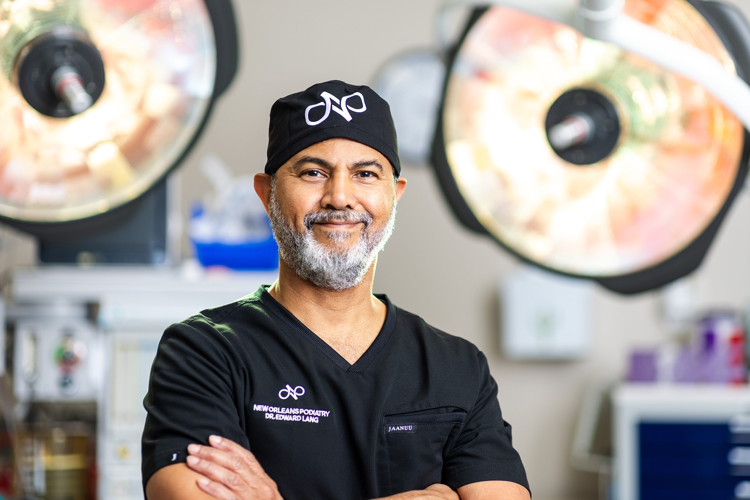 Smiling surgeon in medical environment, surgical lights background.