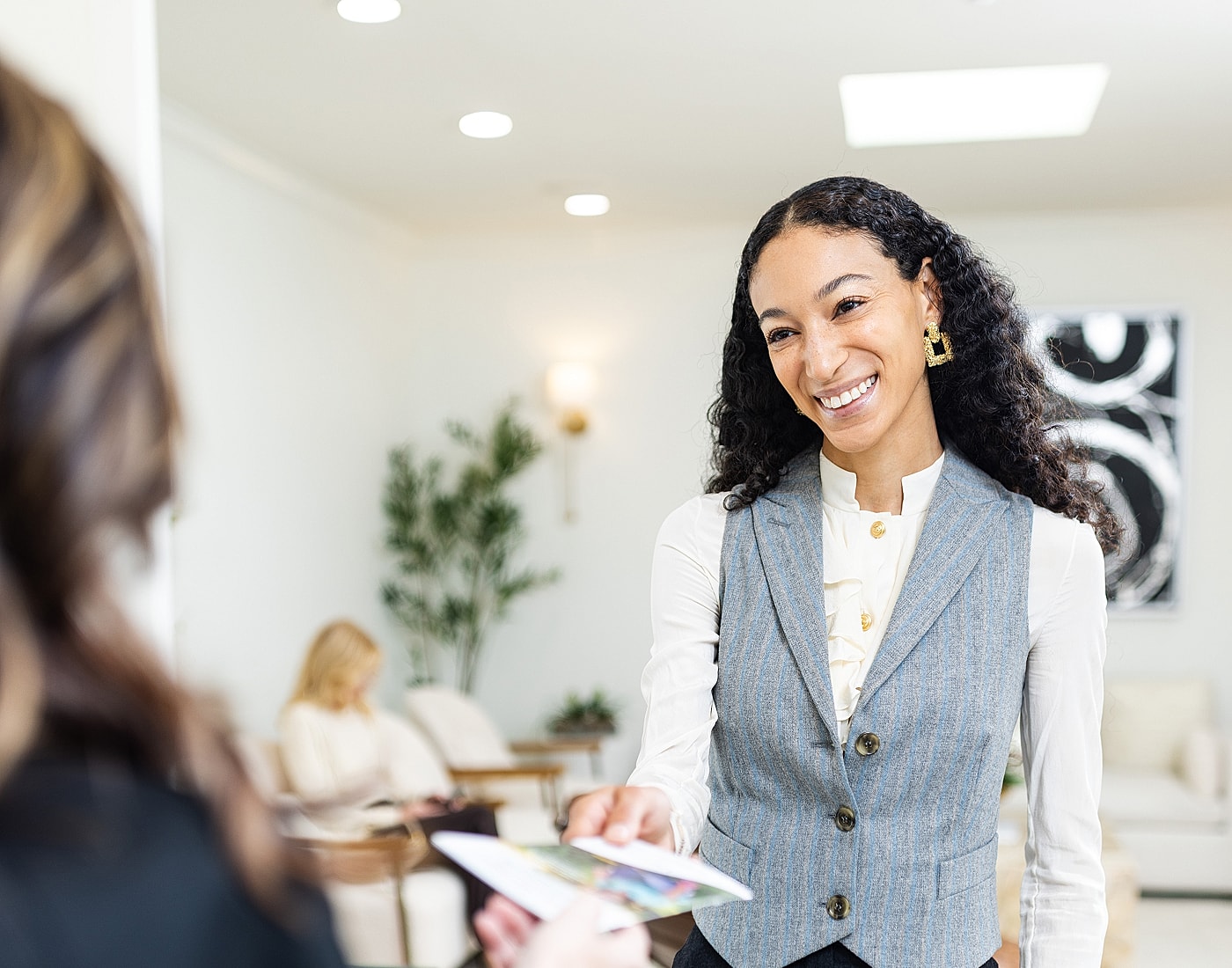 Two women interacting at a reception desk.