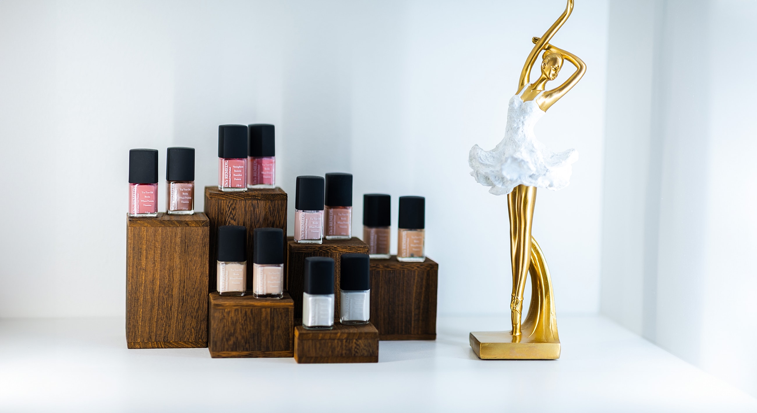 Nail polishes displayed with a decorative statue.
